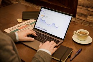 a person typing on a laptop on a table by Sortter courtesy of Unsplash.